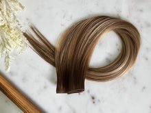 Load image into Gallery viewer, Wide view of the Amanda warm bronde hybrid hair extension weft and color blend
