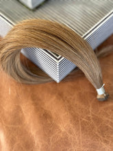 Load image into Gallery viewer, Angled view of the Chai Tea dirty blonde hand-tied hair extension weft