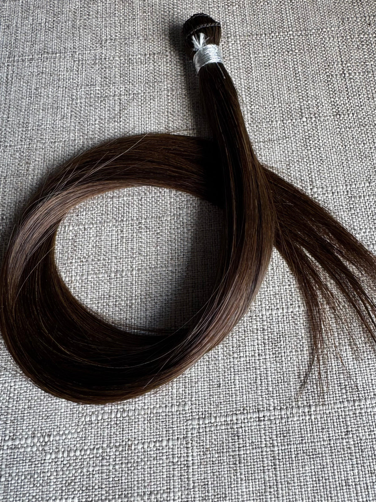 Rachele dark brown hand-tied hair extension weft arranged in a full loop