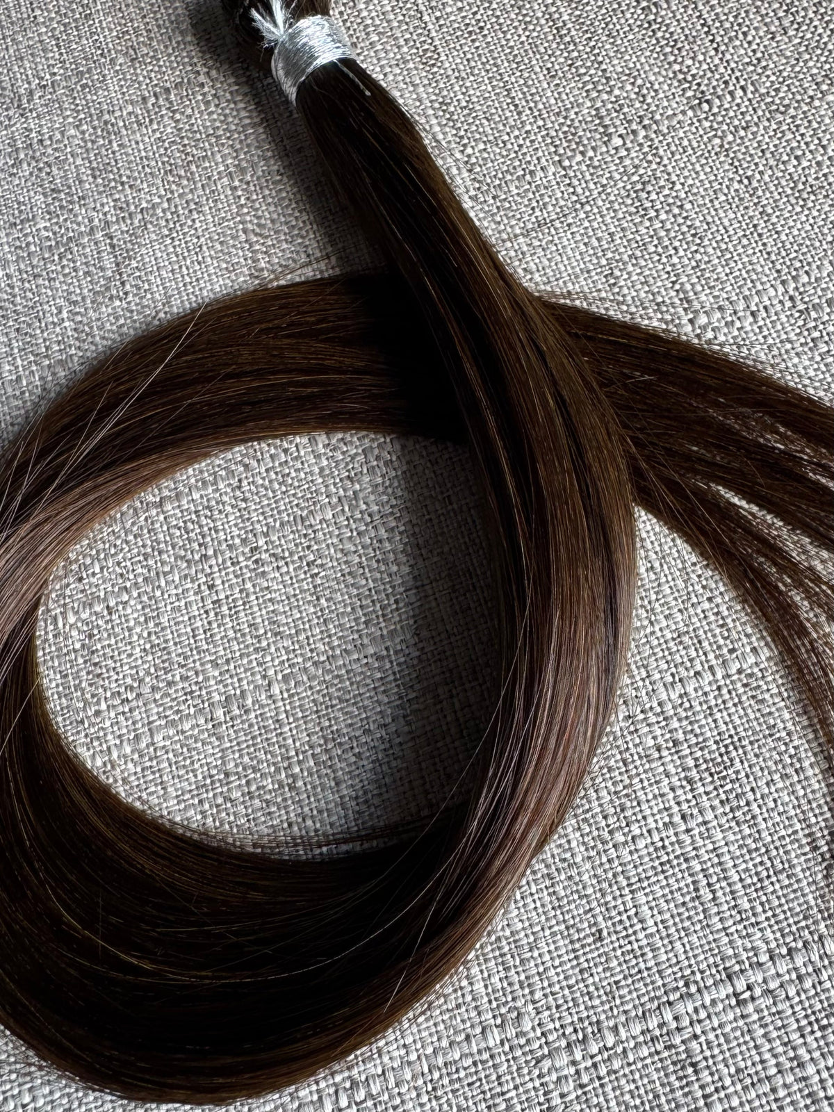 Close view of the Rachele dark brown hand-tied hair extension weft color and texture